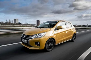 Gelber Mitsubishi Space Star fährt auf der Straße
