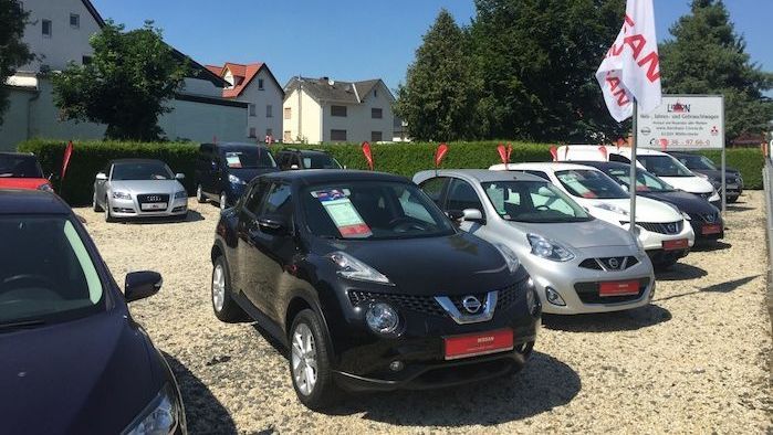Zum Verkauf stehende Fahrzeuge von Nissan auf dem Hof des Autohauses Lisson